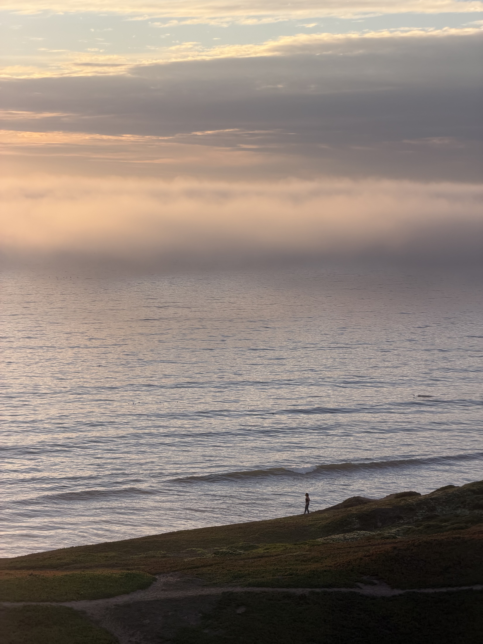 A lone walker along the coastal path above the sea